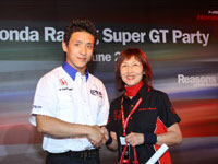 Mr. Katsuyuki Hiranaka from Nakajima Racing presenting a prize to a lucky draw winner.