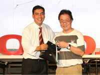 En Azman presenting the prize to a lucky winner, Mr Sebastian Lim from The Sun.